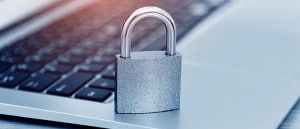 A lock sitting on top of an open laptop